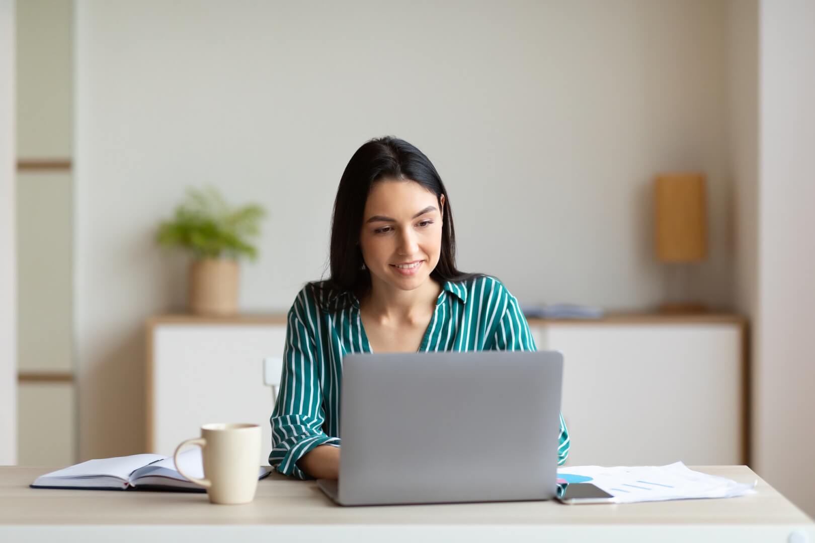 businesswoman-working-on-laptop-sitting-at-workplace-in-office.jpg