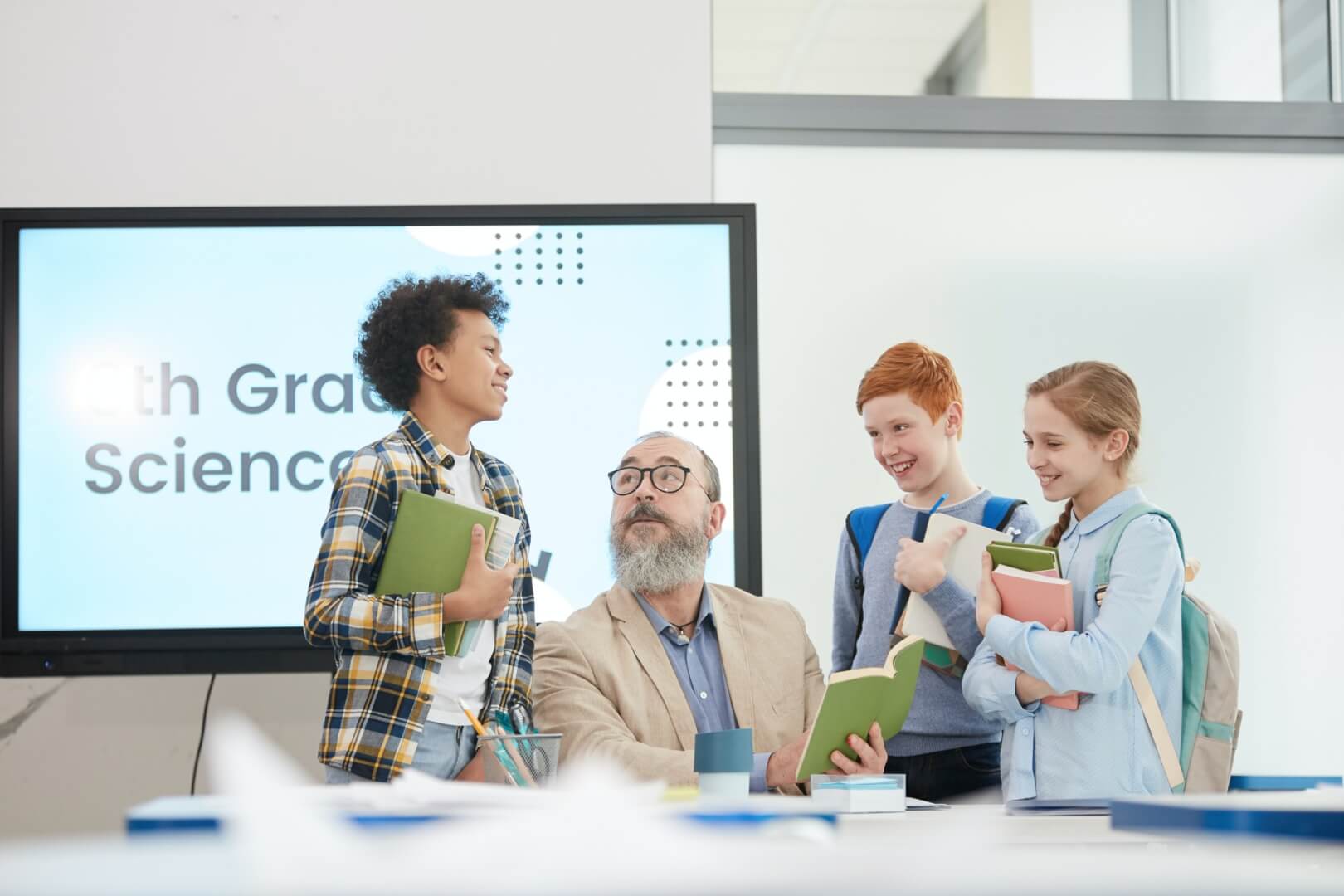 group-of-kids-talking-to-teacher-in-school.jpg